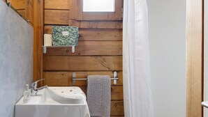 Een badkamer met een houten inrichting, een raam, een wastafel en een handdoekhouder.