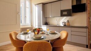 A modern kitchen with a built-in microwave, a coffee maker, and a kettle on the countertop. - DEZA Colosseum view (Roma)