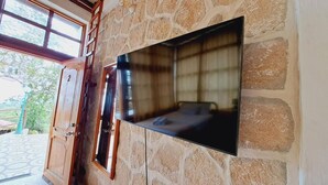 Una pared de piedra con un televisor de pantalla plana.