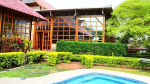 Un edificio con amplios ventanales y una piscina al frente.