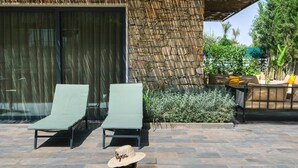 A pool area with two lounge chairs and a person sitting on the edge. - Villa Syria Luxe à Marrakech (Marrakech)