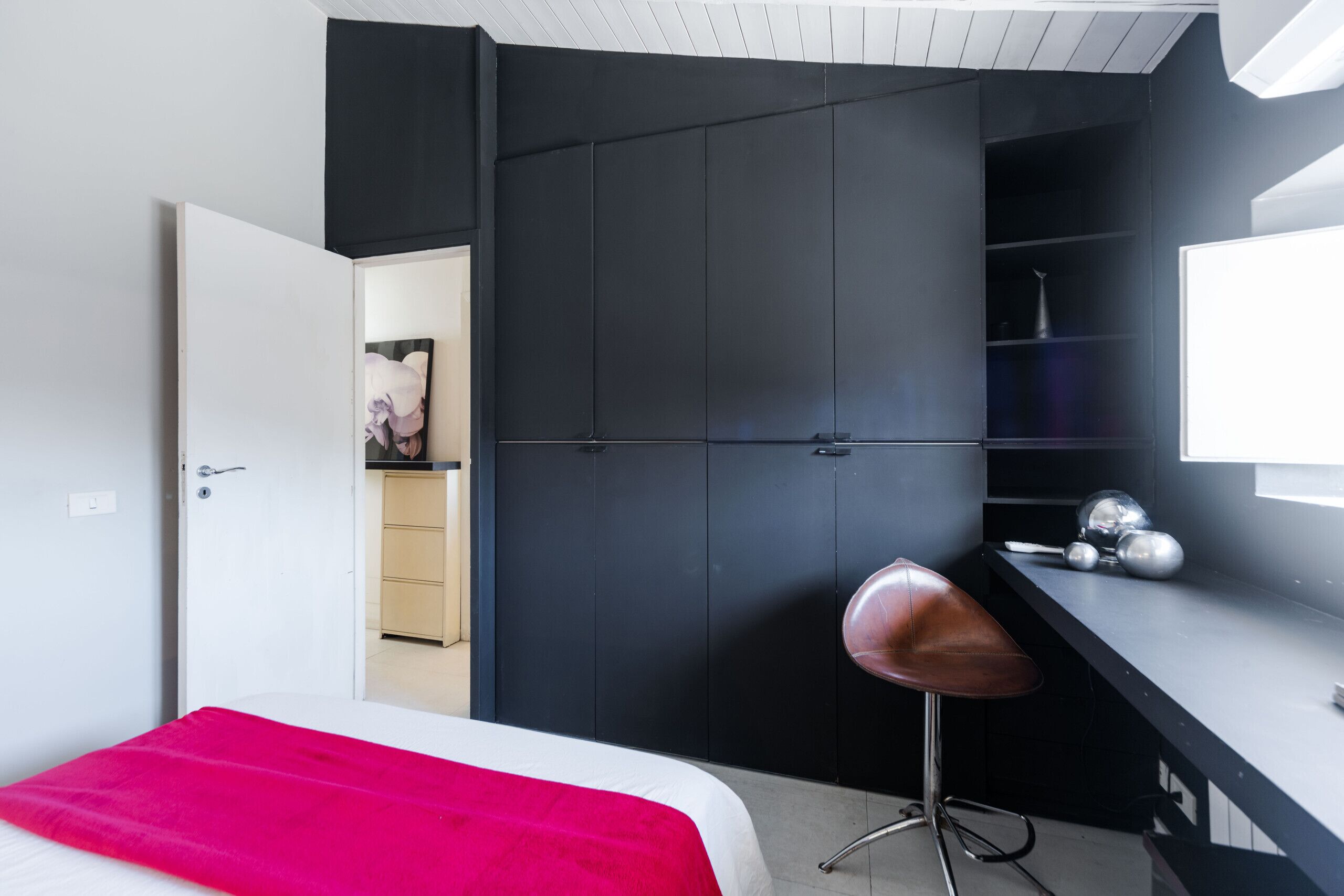 A modern bedroom with a bed, a desk, and a chair.