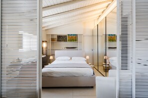 Een moderne slaapkamer met een groot bed, nachtlampjes, een nachtkastje en een spiegel.