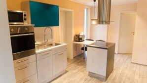A modern kitchen with a built-in oven, a sink, and a compact island.