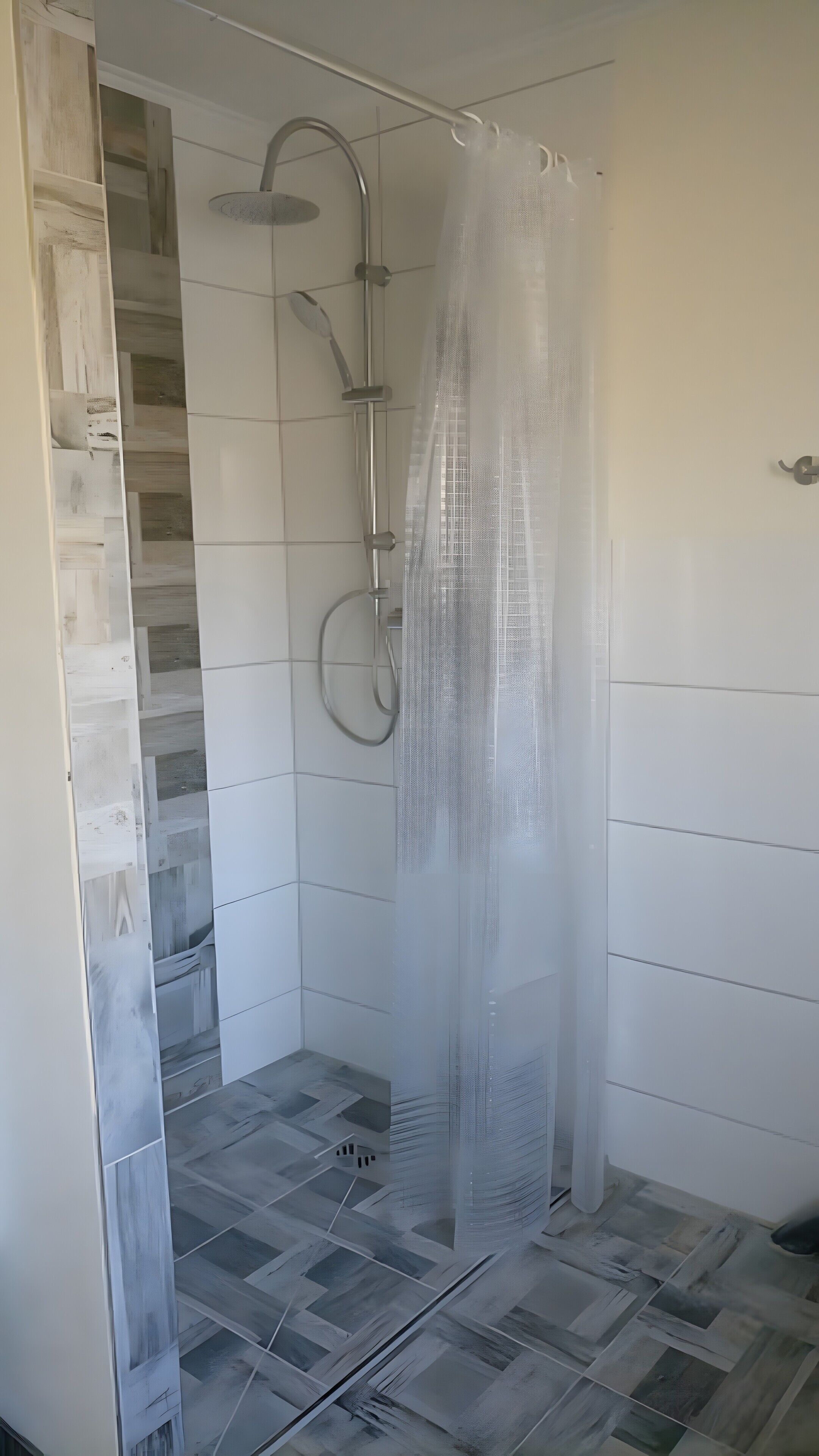A shower with a glass door, a showerhead, and a curtain.