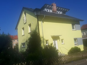 A two-story building with a flat roof, a chimney, and multiple windows. - Studio Apartment 'Vollumen 1' with Balcony (Redwitz an der Rodach)