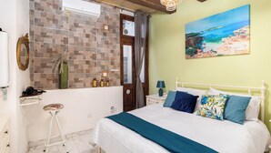 A bedroom with a bed, a nightstand, a mirror, and a window with curtains. - Traditional Townhouse - Rooftop Seaviews (Cospicua)