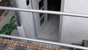 Een gebouw met een witte gevel, een deur met een raam en een klein raam met het nummer 11.