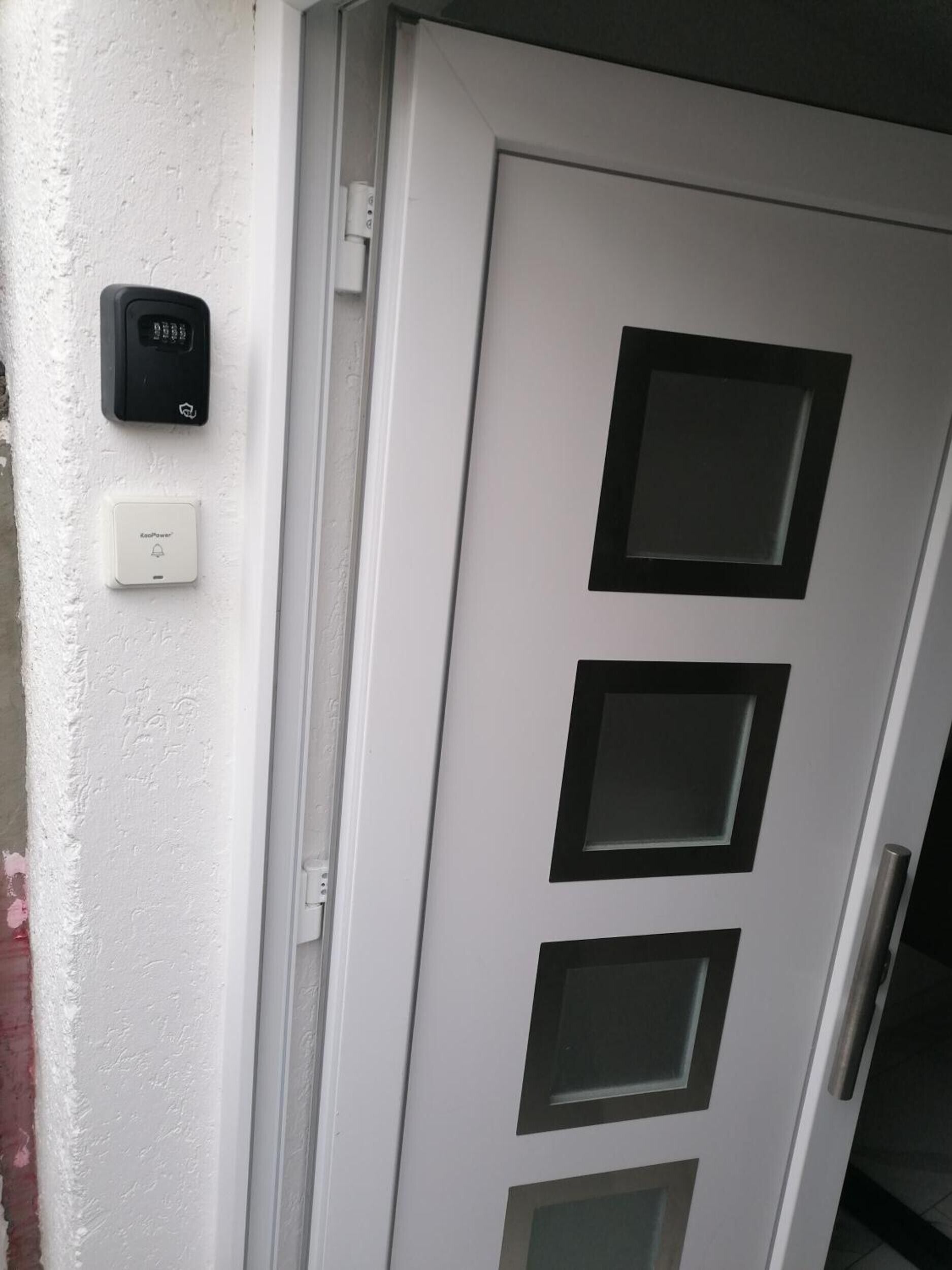 A white door with three rectangular windows and a doorbell.