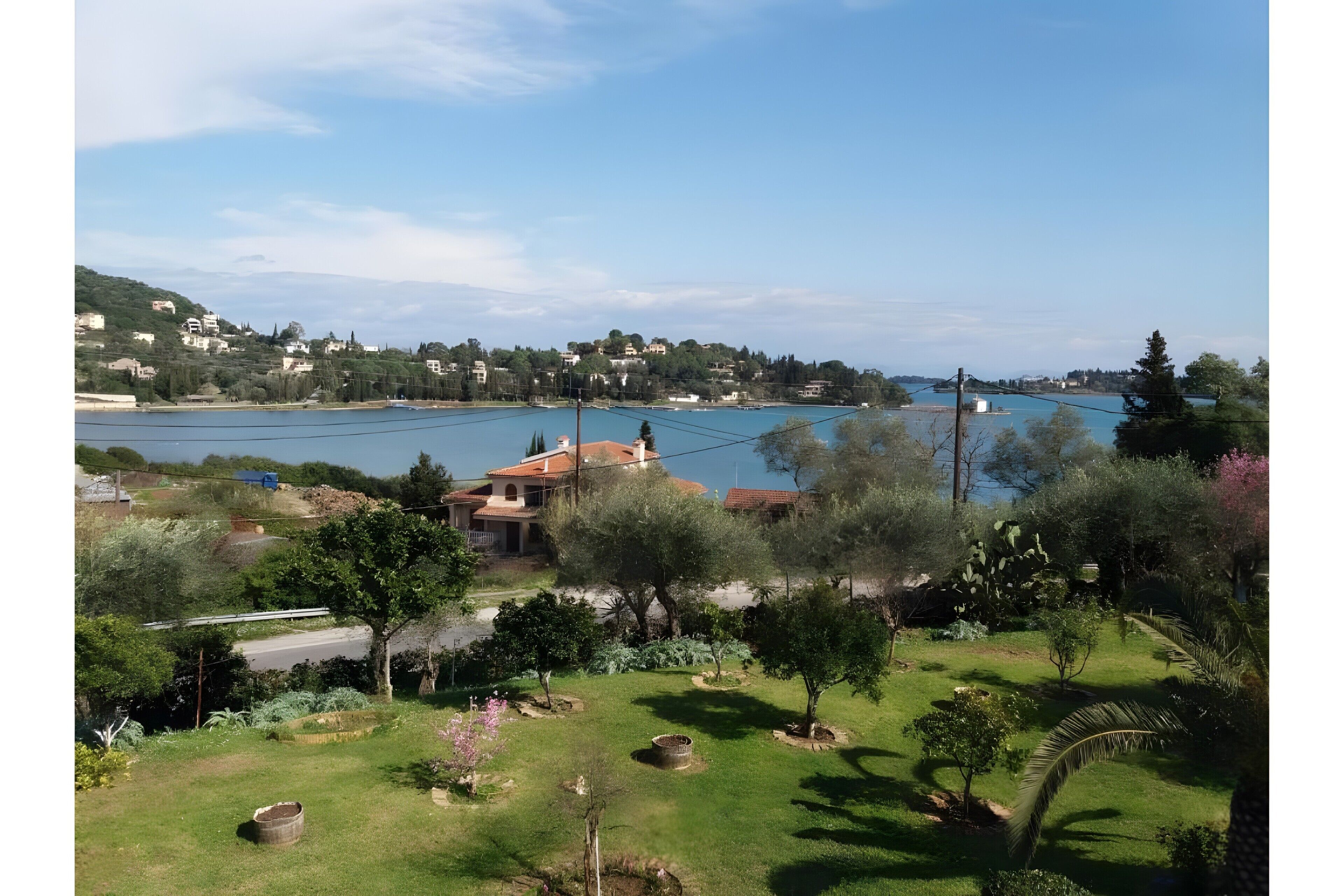 A residential area with houses, a body of water, and greenery.