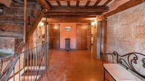 A wooden staircase with a metal railing, a stone wall, and a bench. - Casa Rural La Moixella: Catalan Country House with Private Pool and Pyrenees Views (Lladurs)
