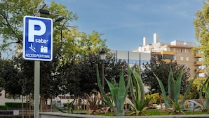 A parking sign with a pedestrian symbol and a wheelchair symbol, indicating accessibility. - Gavidia Center Premium Suites Apartment with Wi-Fi and Air Conditioning (Seville)