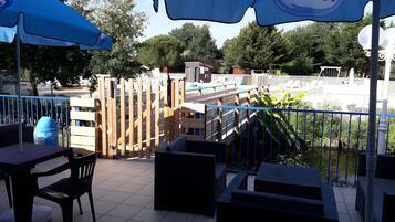 En patio med udendørs møbler, en pool og udsigt over poolområdet.