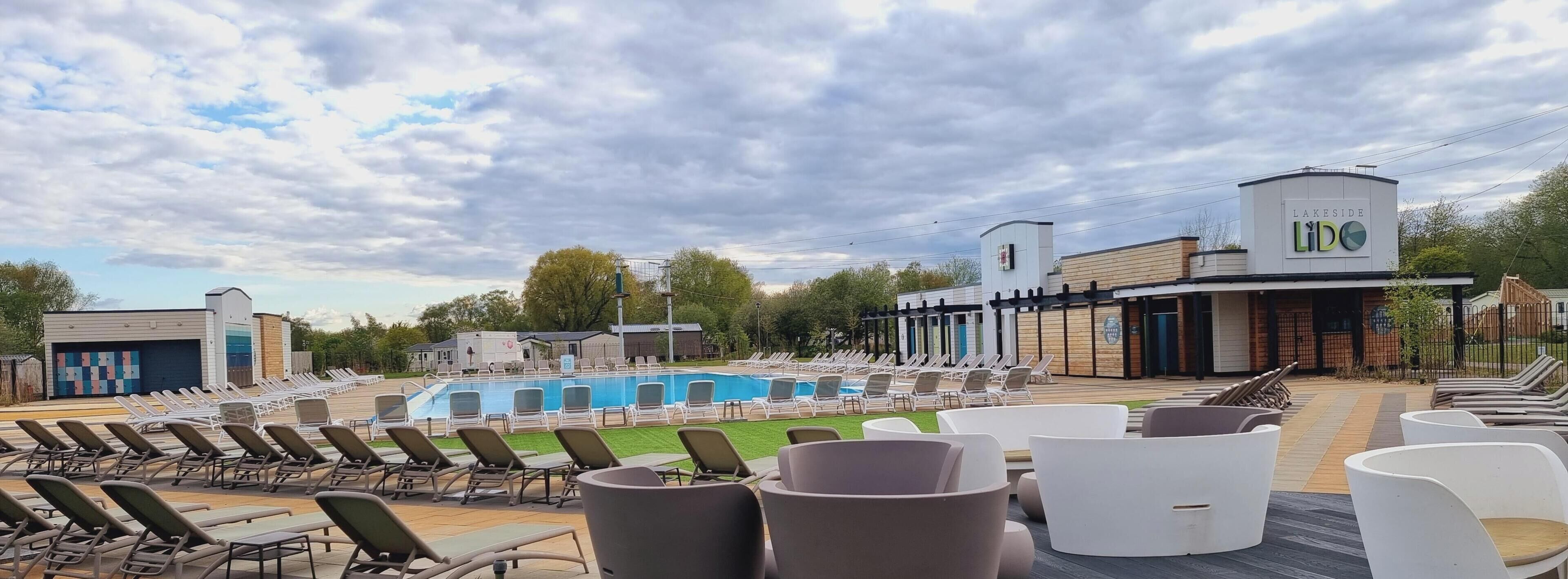 A poolside area with lounge chairs and a swimming pool.