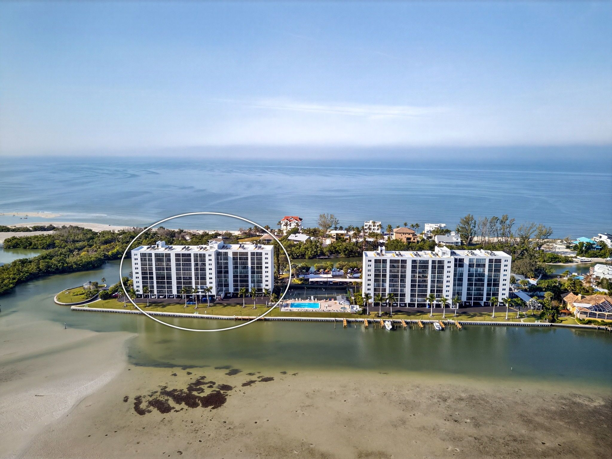 Een hoog hotel met verschillende verdiepingen, een zwembad en uitzicht op de oceaan.