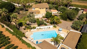 An aerial view of a large house with a swimming pool, surrounded by palm trees and vineyards. - Apartment 'Depandance with Shared Pool', Wi-Fi and Air Conditioning (Marsala)