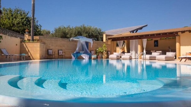 A clear swimming pool with lounge chairs and a covered area. - Apartment 'Depandance with Shared Pool', Wi-Fi and Air Conditioning (Marsala)