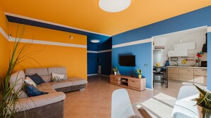 A modern living room with a sofa, a glass coffee table, and a TV. - Apartment 'Araba Fenice' with Sea View, Wi-Fi and Air Conditioning (Marsala)