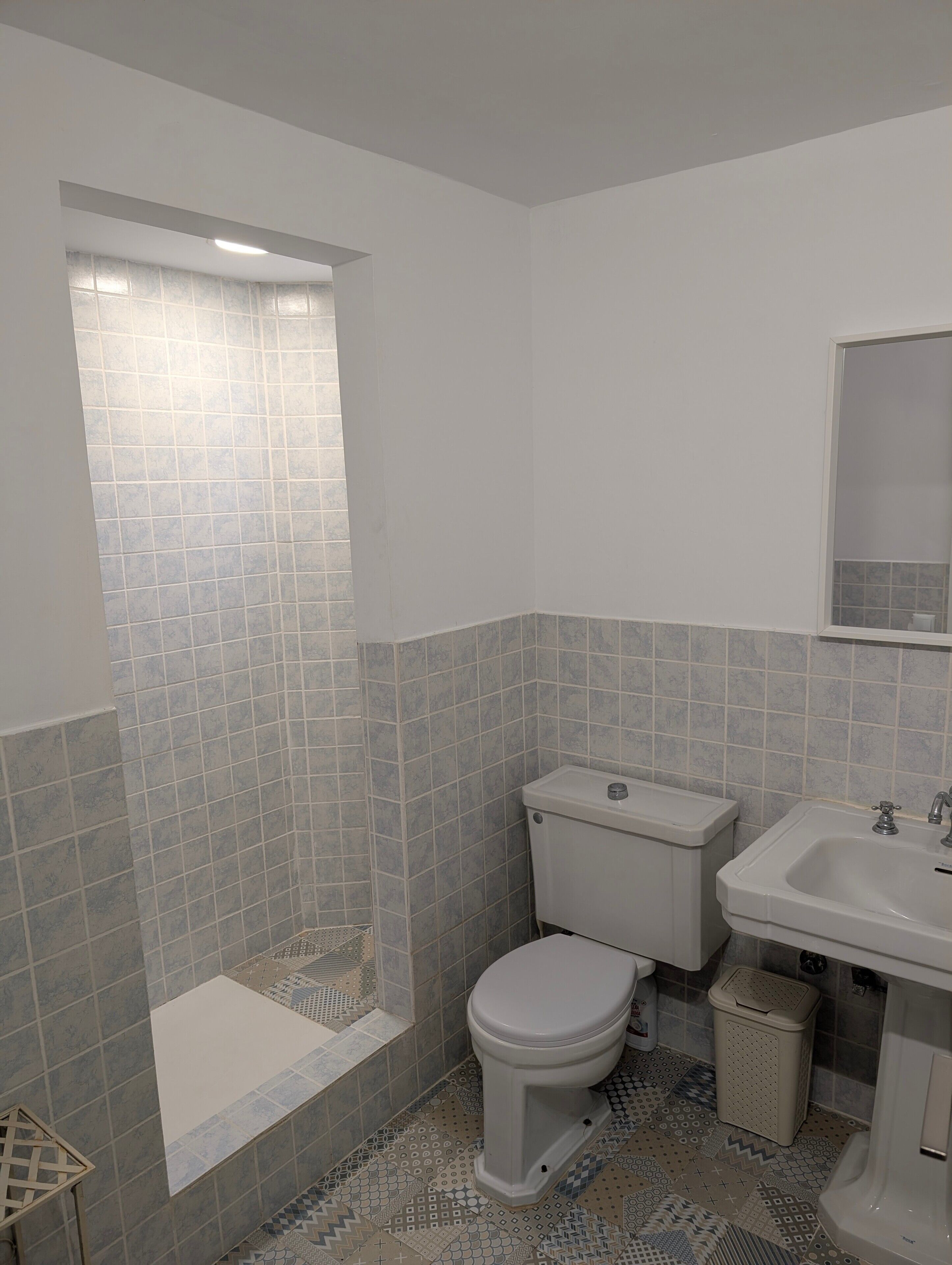 A bathroom with a toilet, sink, and shower.
