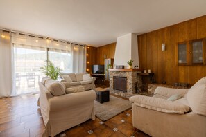Un salon avec une cheminée, des murs en bois et un canapé.