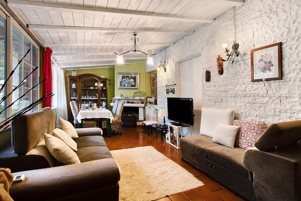 A living room with a sofa, a television, and a fireplace.