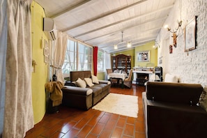 A cozy living room with a sofa, a coffee table, and a fireplace.