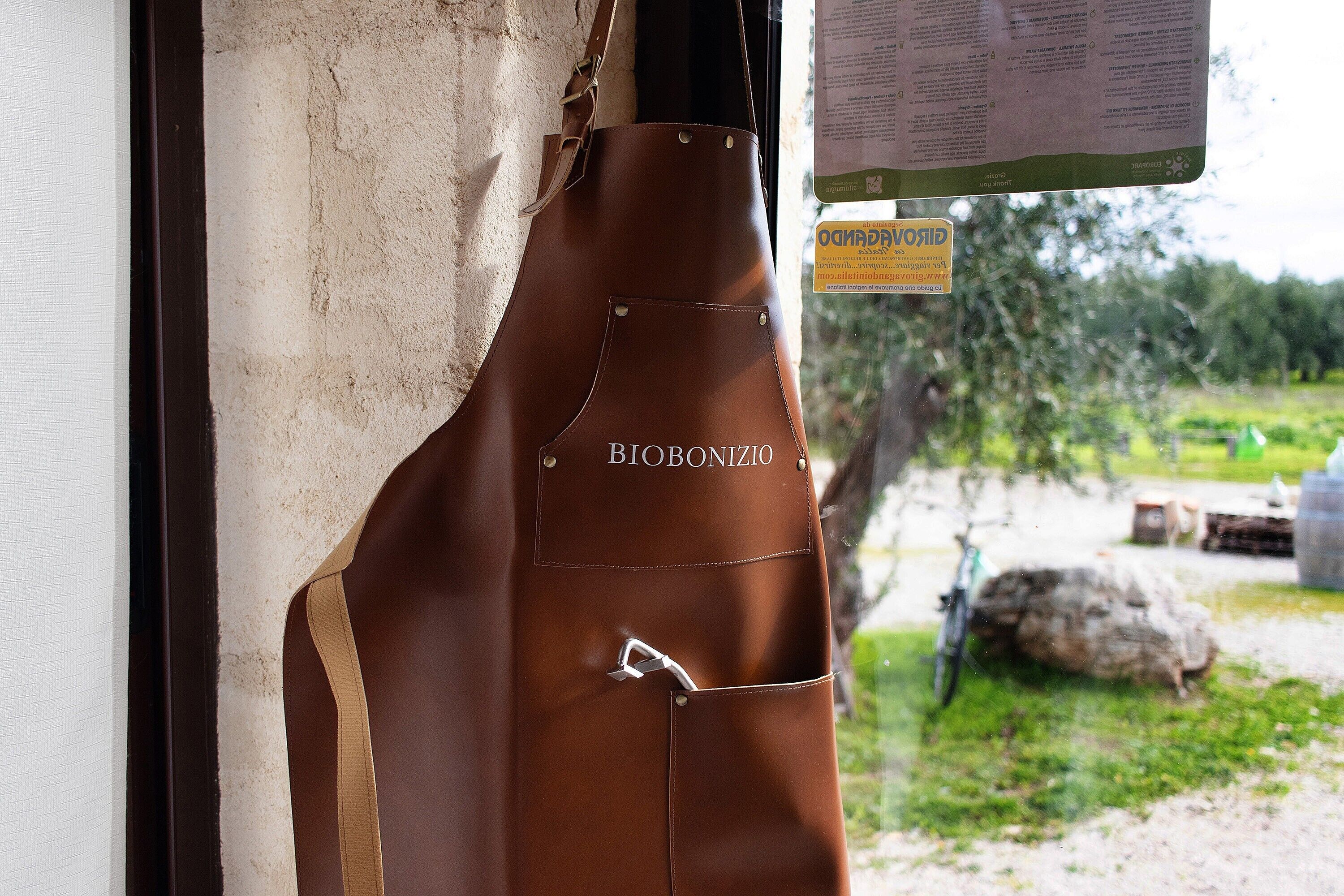 A brown apron with 'BIOBONIZIO' text hanging on a wall.