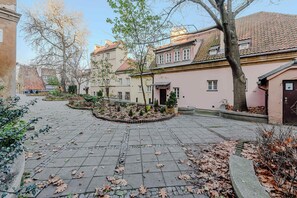 Une cour intérieure dotée d’un chemin pavé, d’arbres et de bâtiments à l’architecture traditionnelle.