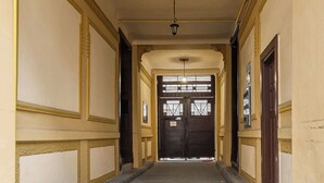 A corridor with a tiled floor, a ceiling light fixture, and a door at the end. - Lumina bright apart near the city center (Łódź)