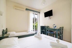 Habitació d'hotel amb dos llits, televisió, escriptori i finestra amb vista.