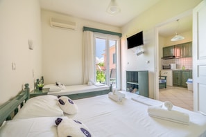 Ein Hotelzimmer mit Bett, Fernseher, Küchenzeile und Balkon.