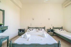 Ein Schlafzimmer mit zwei Betten, einem Nachttisch, einer Kommode und einem Spiegel.