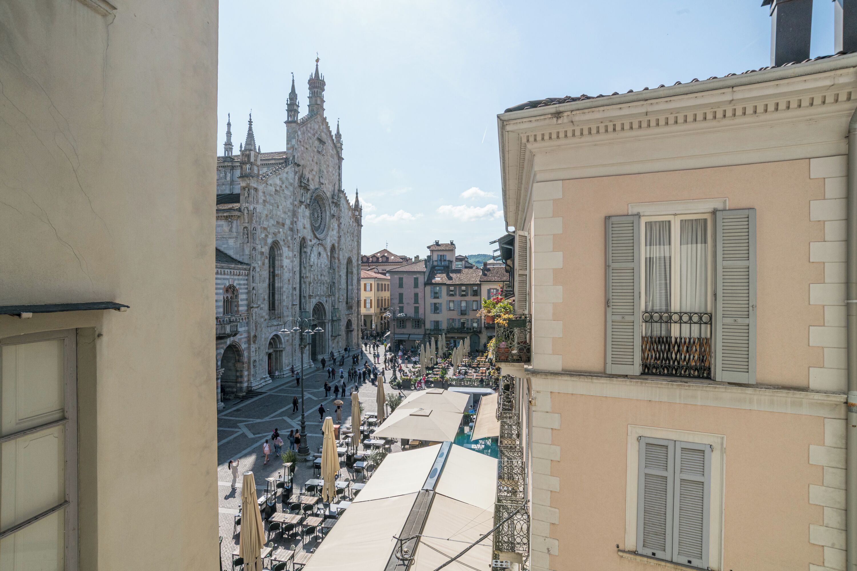 Vista de una calle con una iglesia histórica y edificios con balcones y contraventanas.