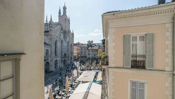 Vista de una calle con una iglesia histórica y edificios con balcones y contraventanas.