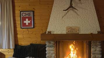 Une pièce chaleureuse avec une cheminée, une enseigne portant les lettres « CHE » et une croix, et une autre enseigne indiquant « Montis ».