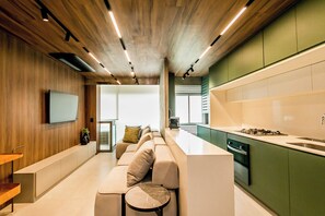 Una cucina moderna con isola integrata, mobili verdi e soffitto in legno.
