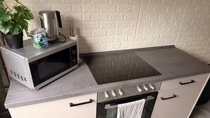 A compact kitchen with a microwave, kettle, and a small potted plant. - Apartment 'Rosenhaus' with Shared Terrace and Wi-Fi (Merchweiler)