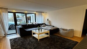 A modern living room with a sofa, a coffee table, and a bean bag. - Apartment 'Rosenhaus' with Shared Terrace and Wi-Fi (Merchweiler)