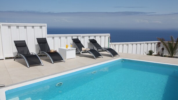 A pool with four lounge chairs and a small table with a drink. - Luxury villa with heated pool and exceptional sea and canyon views, (Barlovento)