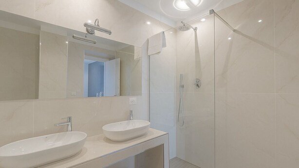 A modern bathroom with two sinks, a shower, and a mirror. - Hotiday Pozzuoli (Pozzuoli)