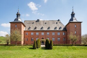 A large brick building with two towers, a central entrance, and a well-maintained lawn. - Apartment 'Fewo Saalstube, Adolphsburg' with Shared Garden and Wi-Fi (Kirchhundem)