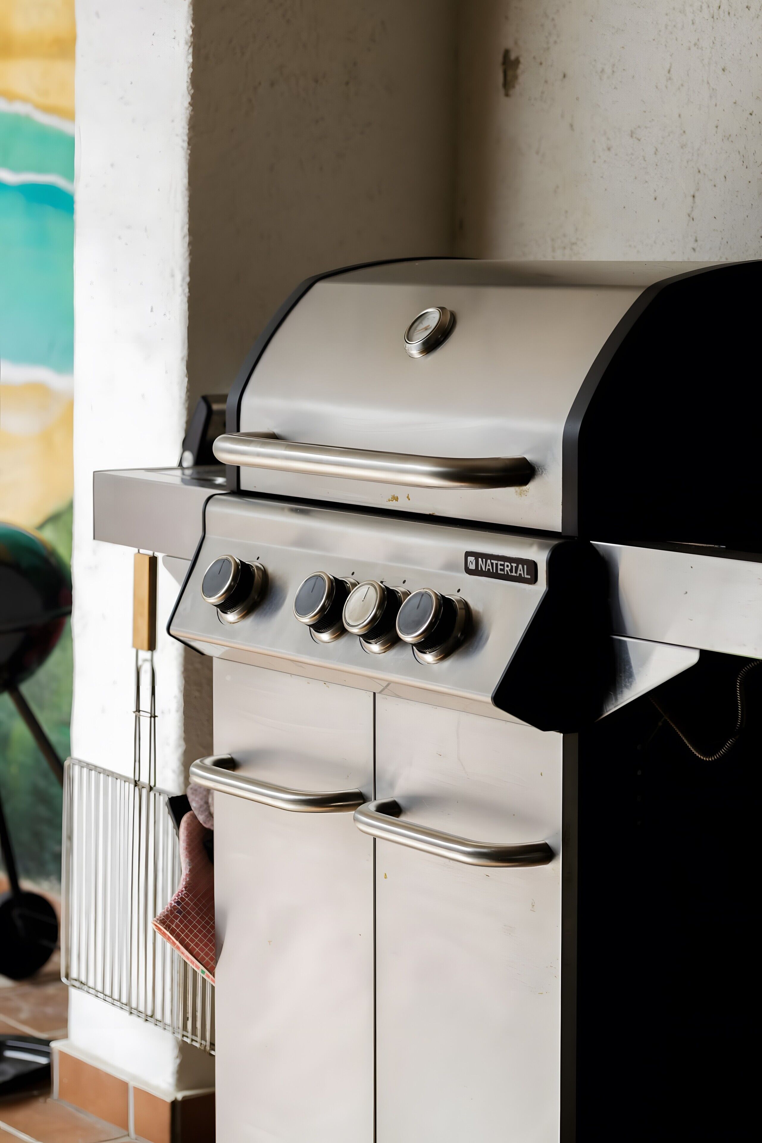 Een roestvrijstalen buitenbarbecue met bedieningspaneel en ventilatie.
