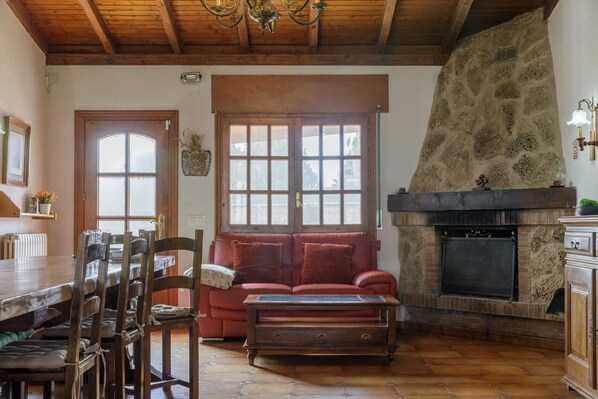 A rustic interior with a stone fireplace, wooden furniture, and a dining area. - Casa Rural Oliver Bardenas – Rural Charm Near Bardenas Reales, Navarra (Valtierra)