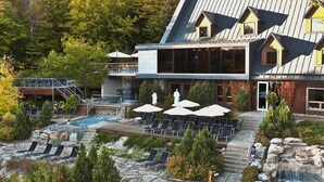 Un complexe hôtelier doté d’une piscine, de chaises longues et d’une cascade.