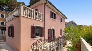 Ein zweistöckiges Gebäude mit Balkon und Treppe.