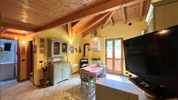 Una cucina con zona pranzo, televisione e finestra con vista.