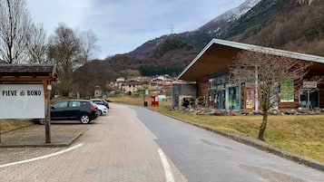 Una strada asfaltata che conduce a un edificio con un cartello che recita 'PIEVE di BONO'.