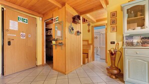 Un interior de madera con una puerta, un espejo, una estantería con botellas y un armario.