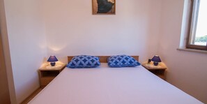 A single bed with a white mattress and two matching pillows, flanked by two bedside tables with lamps. - Josip / Josip A2+1 in Punta Kriza (Punta Kriza)
