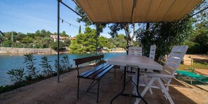 An outdoor seating area with a table and chairs, a bench, and a canopy. - Josip / Josip A2+1 in Punta Kriza (Punta Kriza)